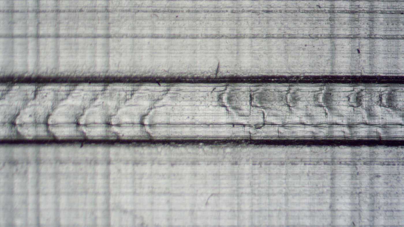 Close-up of a 3D printed microfluidic herringbone mixer. The structure is very vague, with clearly visible layers.
