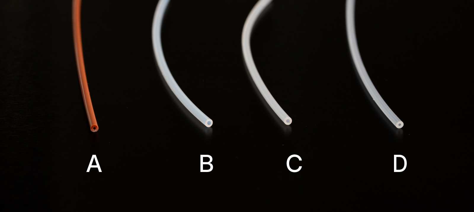 Four types of 1/16" diameter capillary tubing. From left to right: PEEK - labelled A, PTFE - labelled B, ETFE - labelled C, and PFA - labelled D.