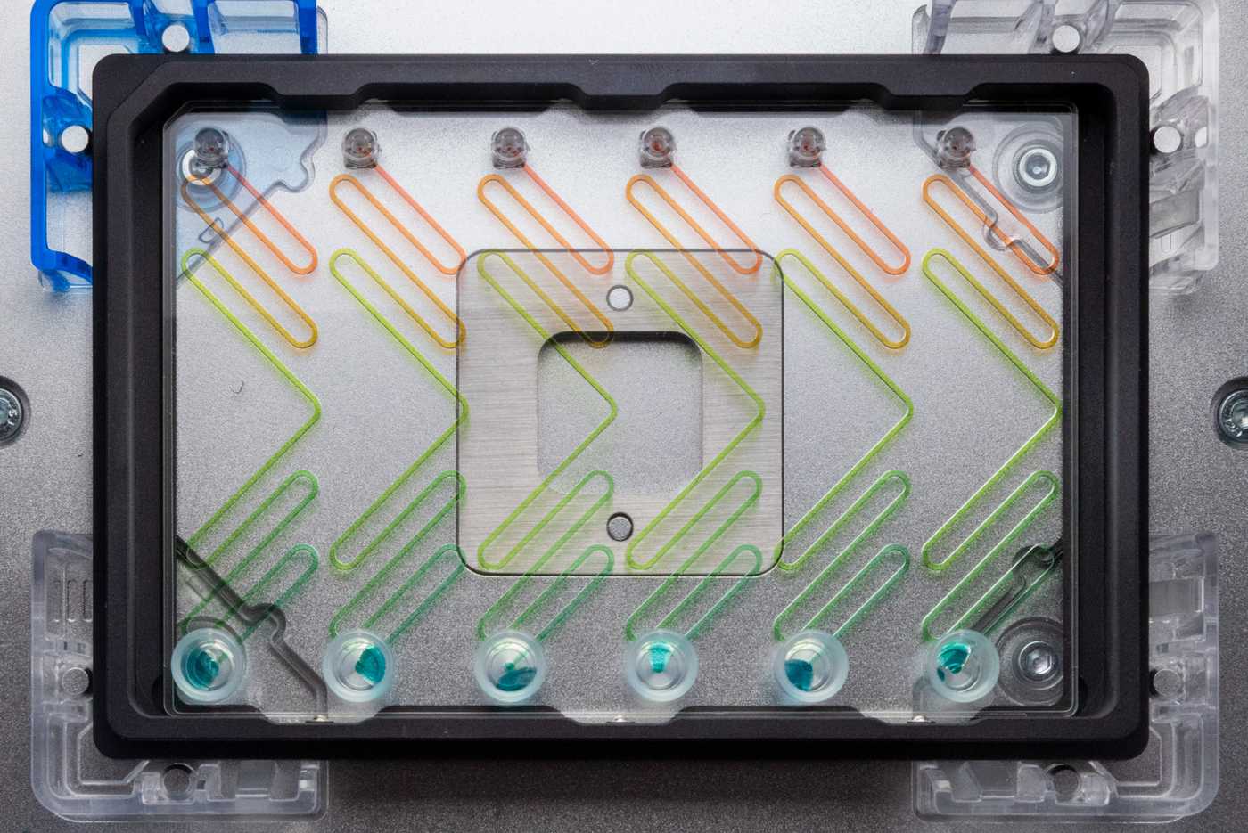 A microfluidic device in an SLAS adapter, secured to a liquid handler’s deck.